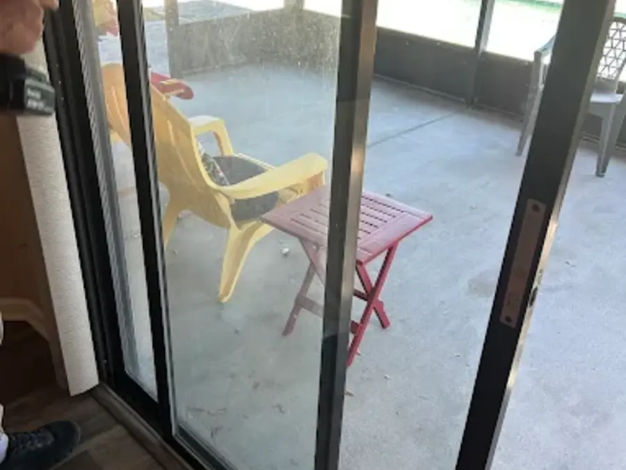 A residential sliding glass door opening to a screened patio