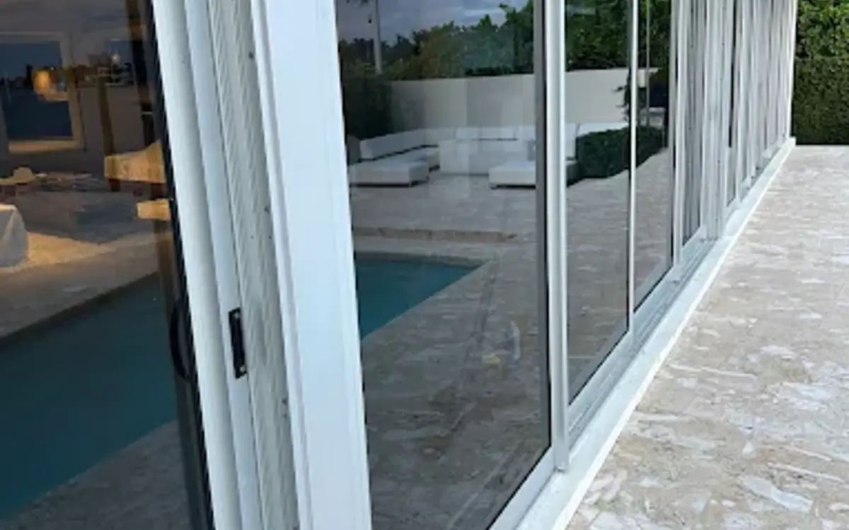 A well-maintained multi-panel sliding glass door along a pool
