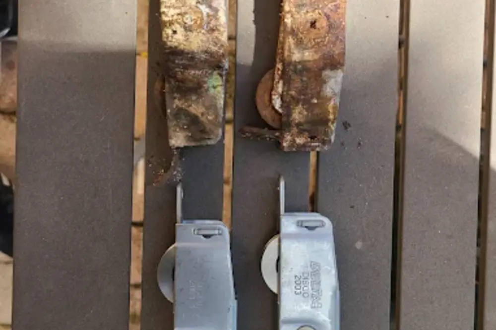 Corroded sliding door track and stiles from coastal salt exposure