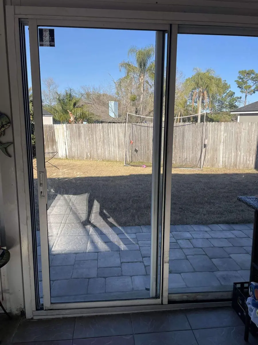 Technician removing a sliding patio door panel with suction lifts