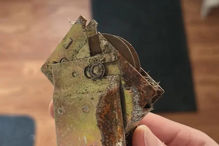 Sliding door roller housing seized and rusted through from salt-air corrosion