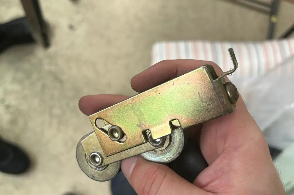 A corroded sliding door roller removed from a heavy door