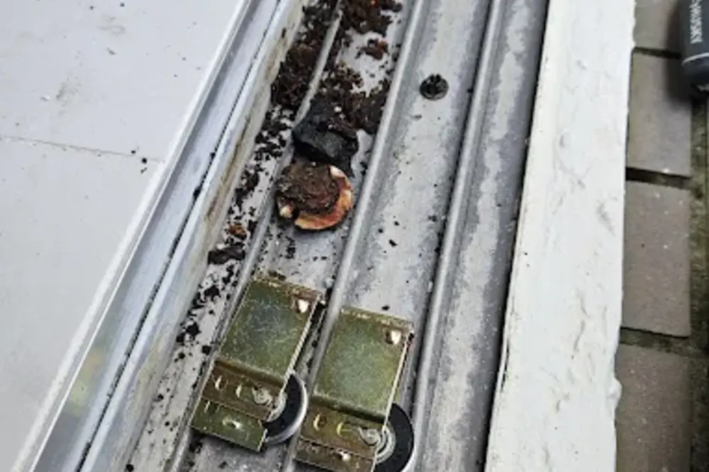 Sliding door rollers seated in a worn track before repair